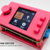 NodeAxe SeedSigner — Pink OpenFrame SeedSigner in a pink NodeAxe open-frame case with joystick and three buttons.